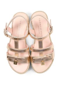 Złote metaliczne sandały z wieloma paskami, ozdobą w postaci kokardki i różową wkładką. Posiadają regulowaną klamrę i kontrastowe przeszycia.