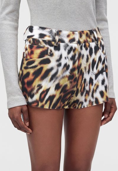 Άτομο που φοράει σορτς με animal print και εμπρόσθιες τσέπες και ανοιχτό γκρι ριμπ μακρυμάνικη μπλούζα, εμφανίζεται από τη μέση έως το μέσο του μηρού.