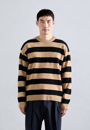Gestreifter Pullover in Schwarz und Beige, aus weichem Material, mit Rundhalsausschnitt, lockerer Passform und gerippten Bündchen und Saum für zusätzliche Textur.