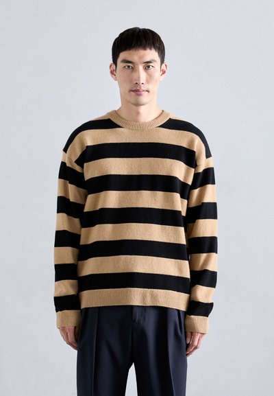 Sort og tan-stribet sweater, lavet af blødt stof, har runde halsudskæring, løs pasform og ribbede manchetter og kant for ekstra tekstur.
