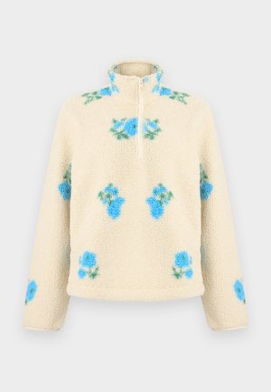 Kreemjas fliisist pullover poollukuga kraega, kaunistatud esiküljel, varrastel ja õlgadel siniste ja roheliste lillemotiivide kirjumustriga.