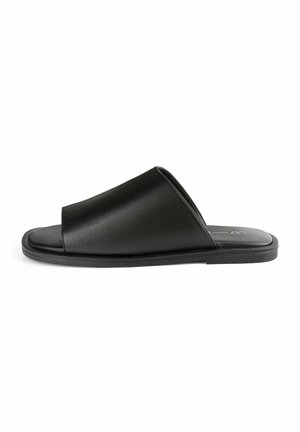 Infradito nere in plastica sintetica, con un design a fascia ampia e una suola testurizzata per migliorare la presa. Stile minimalista.