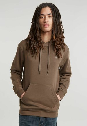 Sweatshirt à capuche marron avec une poche frontale, des cordons réglables et des poignets côtelés. Le tissu semble lisse avec une texture uniforme.