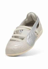 Μπεζ αθλητικό παπούτσι slip-on με ασημί λογότυπο Puma και τρεις ελαστικές λωρίδες στο πάνω μέρος, με ασημί υφη στην πλευρική λεπτομέρεια.