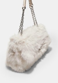 Piccola borsa rettangolare bianca in pelliccia sintetica con catena argentata e manici in pelle su uno sfondo semplice.