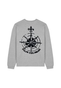 Grijze sweatshirt met een zwart kompasontwerp en de tekst "VOLG JE DROMEN" onder het kompas, met een geribbelde kraag en manchetten.