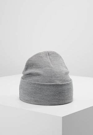 Szara dzianinowa czapka typu beanie z podwiniętym mankietem, prezentowana na białym postumencie na jednolitym szarym tle.
