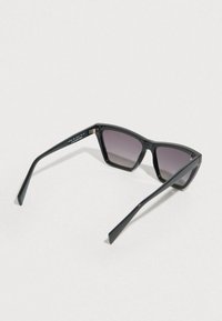 Fekete, szögletes napszemüveg árnyalt lencsékkel, sima műanyag kerettel és mintás szárakkal. Az oldalán kis logó részlet található.