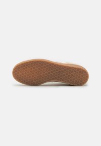 Shoe sole with a textured honeycomb pattern, featuring a light brown rubber material. Smooth edges and a raised design for grip.