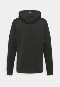 Sudadera con capucha negra de textura suave, de mangas largas y con un pequeño logo en el cuello de la parte trasera. Presenta un diseño minimalista.