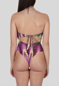 Bikini multicolore tie-dye, con scollatura a halter e chiusura sul retro a fiocco. Il tessuto ha una superficie liscia con tonalità di viola, verde e oro.