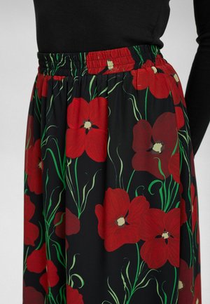 Sukňa s elastickým pásom vyrobená z čiernej tkaniny zdobenej veľkými červenými kvetmi a zelenými stonkami, vytvárajúcimi odvážny kvetinový vzor.