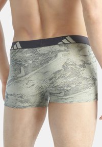 Herrens boxerbriefs i ett grått och gult abstrakt mönster. Har en svart elastisk midjeband med tre vertikala ränder. Mjuk tygtextur.