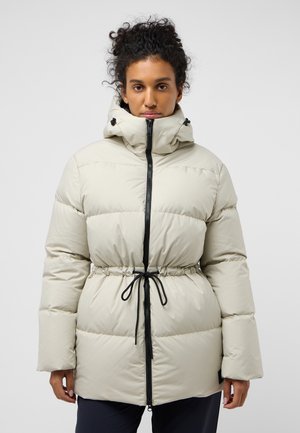 Lichtbeige pufferjack met een getailleerde taille, zwarte rits en verstelbare capuchon. Heeft een gladde, glanzende stof en brede mouwen.