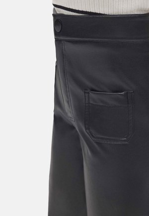 Pantalones de piel negra con una textura suave, cierre lateral con botón y un pequeño bolsillo trasero con detalles de costura contorneada.