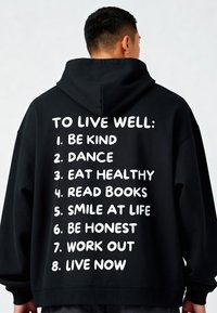 Felpa nera con cappuccio in tessuto. Il retro presenta un testo bianco che elenca otto consigli per il benessere. Vestibilità ampia con polsini e orlo a costine.