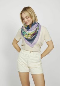 Écharpe en soie multicolore de forme triangulaire, orn�ée de motifs floraux dans des teintes de vert, violet et bleu marine, drapée autour du cou.