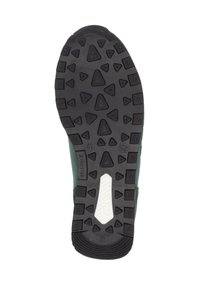 Semelle extérieure en caoutchouc noir avec des motifs triangulaires texturés, présentant une bande blanche centrale. Matière supérieure verte visible le long des bords.