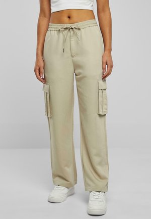Beige cargo bukser med elastisk talje og snor. Har to sidelommer. Bæres med hvide sneakers.
