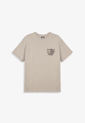 Beigefarbenes Baumwoll-T-Shirt mit kurzen Ärmeln, das ein schwarzes Grafikdesign eines Panzers und den Text "IN-FAMOUS GRMY" in stilisierter Schrift zeigt.