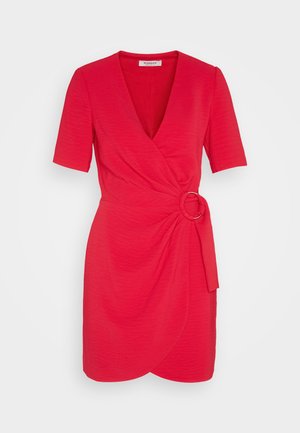 Rochie roșie cu mâneci scurte, cu decolteu în V, design înfășurat și detaliu cu nod la talie, având un accent din cerc metalic și țesătură texturată.
