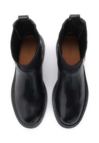 Botine negre din piele, cu un finisaj neted, material ribbed în partea de sus, vârf rotunjit și o verigă subtilă pentru un acces ușor.