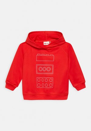 Hoodie rouge en tissu doux, avec des designs en contour blanc de briques LEGO sur le devant. Comprend une capuche et des poignets côtelés.