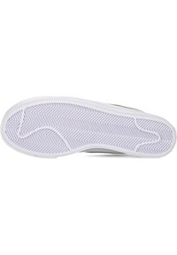 Suela de zapatilla con un patrón de espiga texturizado en púrpura claro, contorneada con un borde de goma blanca. Forma plana y ligeramente curvada.