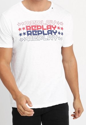 T-shirt blanc avec le mot "REPLAY" imprimé quatre fois en rouge, bleu et blanc, entouré d'étoiles rouges et bleues alternées.