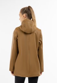 Giacca marrone resistente all'acqua con cappuccio, presenta una texture liscia, maniche lunghe e un taglio leggermente allungato per una maggiore copertura.