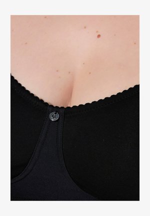 Reggiseno nero realizzato in tessuto liscio, con bordi smerlati, chiusura frontale a bottone e scollatura profonda.