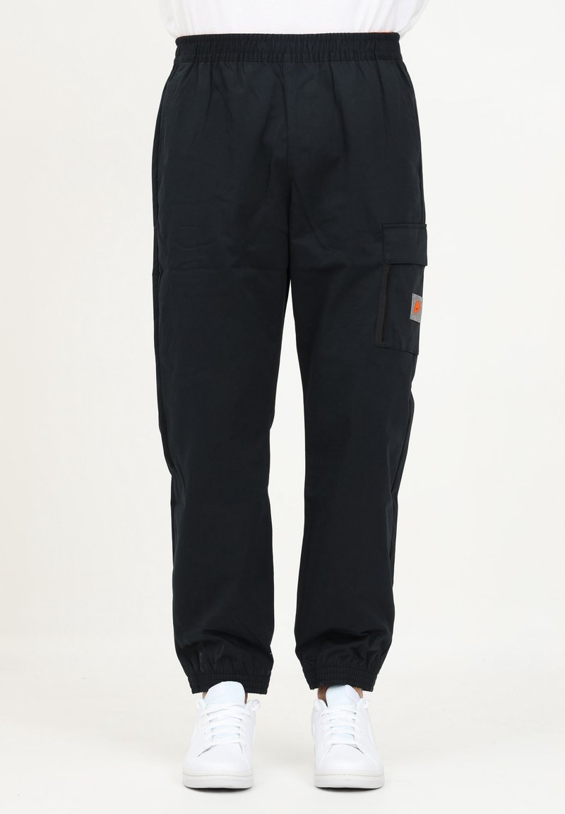 Svart cargobyxor i lättviktigt tyg, med elastisk midja, avsmalnande ärmslut och en sidficka. Styla med vita sneakers.