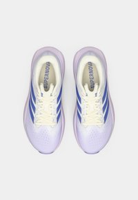 Μωβ και λευκά αθλητικά παπούτσια με μπλε ρίγες, διάτρητο πάνω μέρος, μαξιλαρωμένη σόλα και λευκά κορδόνια. Εμφανίζει το λογότυπο «SUPERNOVA» στο εσωτερικό.