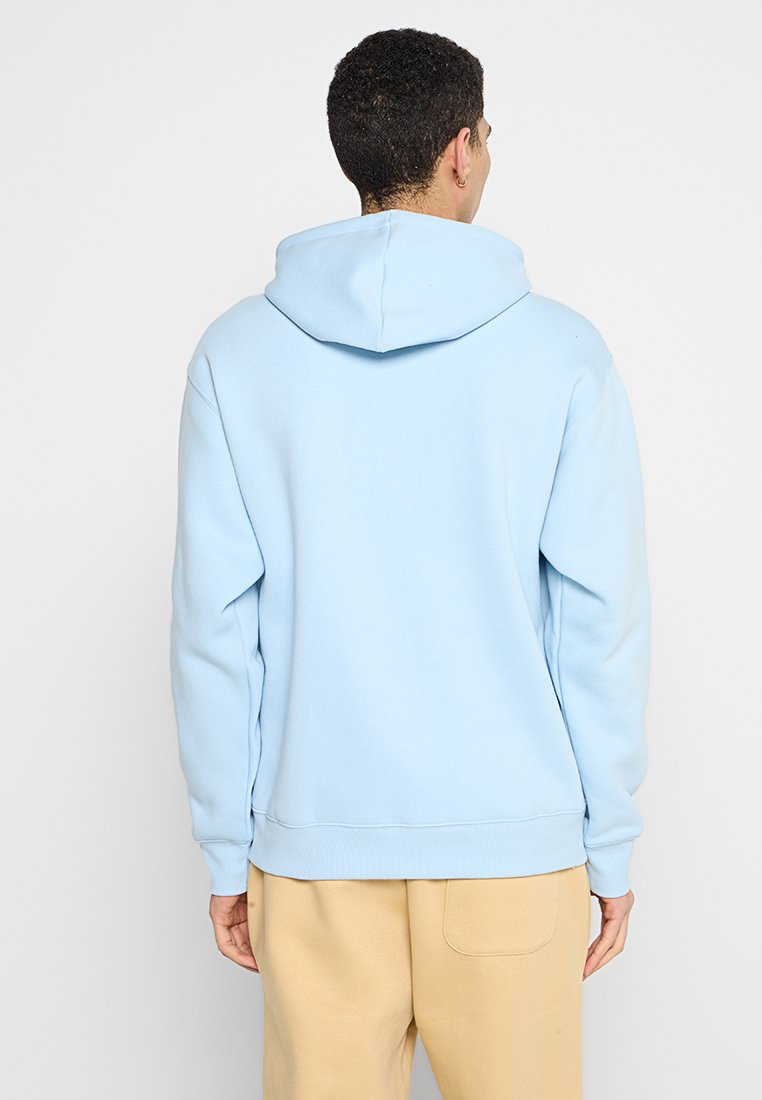 Sweat à capuche bleu clair avec cordons de serrage, fabriqué en tissu doux. Il possède des manches longues et un ourlet côtelé, avec un design minimaliste.