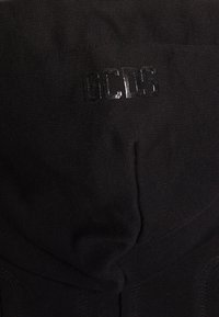 Zwarte hoodie met een gladde textuur, voorzien van een glanzend logo "GCDS" op de capuchon en ribbeldetails langs de randen.