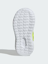 Shoe sole with a textured white rubber surface, featuring a grid pattern and a central branding detail. Accent color is bright yellow.