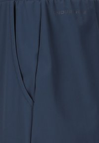 Marineblåt stof med en lynlåslomme i siden og det diskrete "ENDURANCE"-logo øverst til højre.