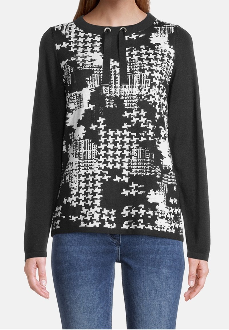 Svart och vit mönstrad stickad sweatshirt med lång ärm, med rundad halsringning och dragsko-detalj vid kragen.