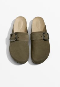 Gröna mocka slip-on sandaler med ett band och rektangulär svart spänne, med en slät fotbädd och rundad tådesign. Stl 37.