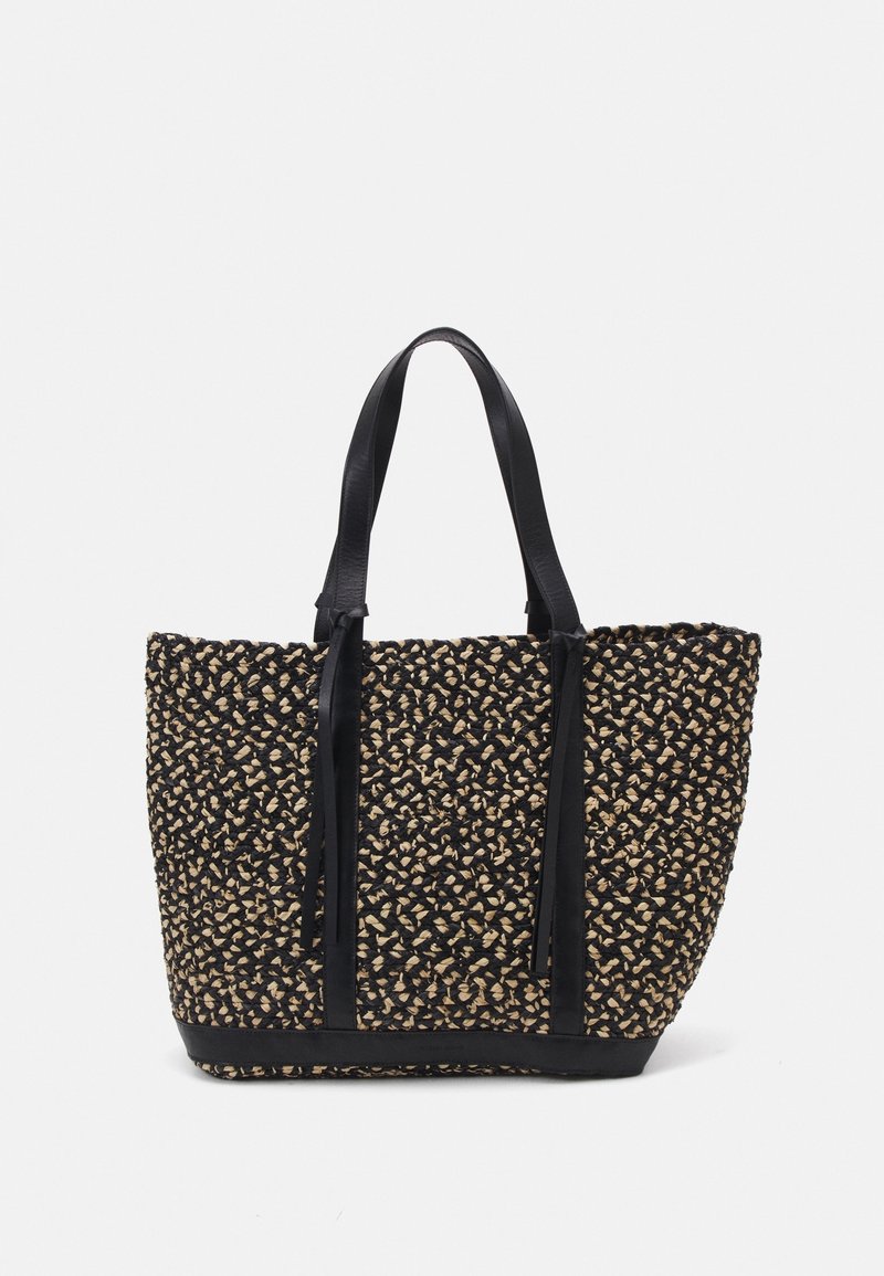 Sac fourre-tout tissé en noir et couleurs naturelles, présentant un motif texturé, des poignées en cuir et une forme rectangulaire structurée.