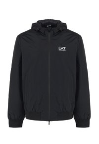 Black hooded jacket with elastic cuffs and hem, featuring a front zipper and an embroidered EA7 logo on the left chest. Lightweight fabric.