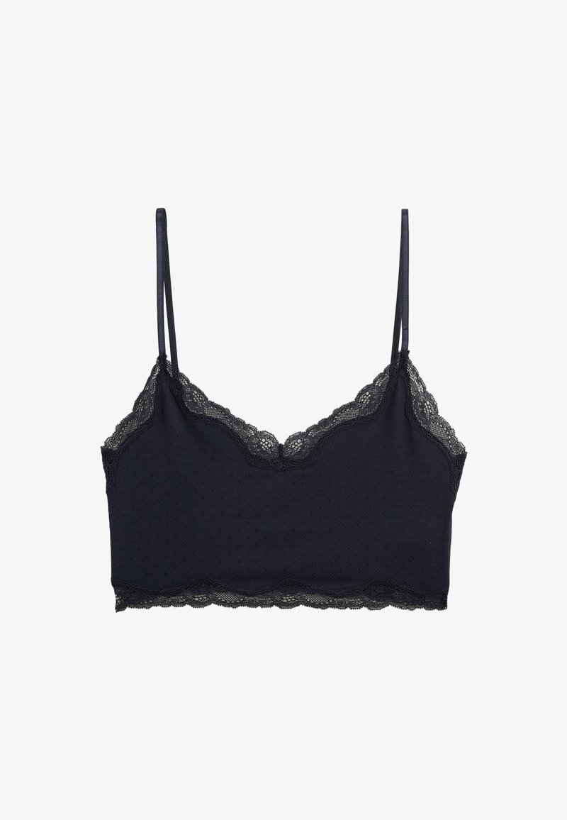 Bralette en dentelle marine foncé avec des bretelles réglables fines et une texture à pois sur le tissu, avec des bords festonnés le long de l'encolure.