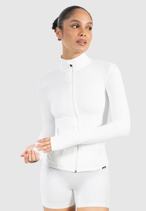 Weißes Zip-Up-Sportjacke mit langen Ärmeln, ausgestattet mit Daumenlöchern und glattem, dehnbarem Material. Entworfen für aktive Bekleidung.