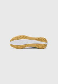 Suela de zapato con un patrón de panal de goma y una plantilla amarilla. Presenta una entresuela blanca y una parte superior multicolor que hace una transición del verde al púrpura.