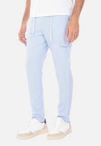 Pantaloni cargo blu chiaro realizzati in tessuto morbido, con tasche laterali, vita elastica con lacci e design a gamba affusolata.