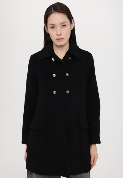 Black wool coat with double-breasted gold button closure, large lapels, and two front pockets. Features a straight cut and soft texture.