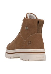 Stivale alto marrone in suede, con collo imbottito, chiusura con lacci e suola in gomma bianca con un motivo testurizzato e logo.