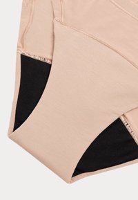 Ropa interior beige sin costuras con una textura suave, que presenta paneles de malla negra en los laterales y costuras reforzadas para mayor durabilidad.