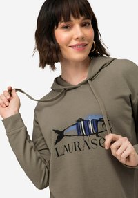 Grå hoodie med en fiskgrafik i blått och svart, med en dragsko i huvan och en avslappnad passform. Mjuk tygtextur och avslappnad design.