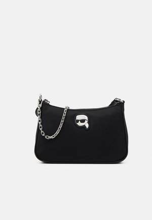 Black handbag with silver chain strap and cartoon patch of a person wearing sunglasses and a ponytail on the front center.